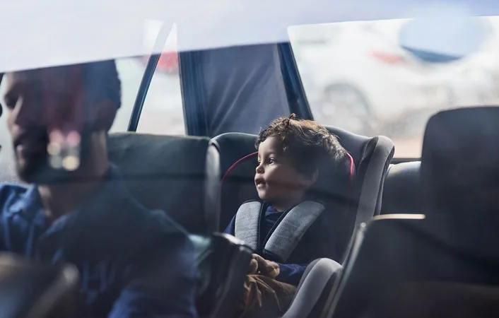 Bambino seduto sul seggiolino nel sedile posteriore dell’auto.