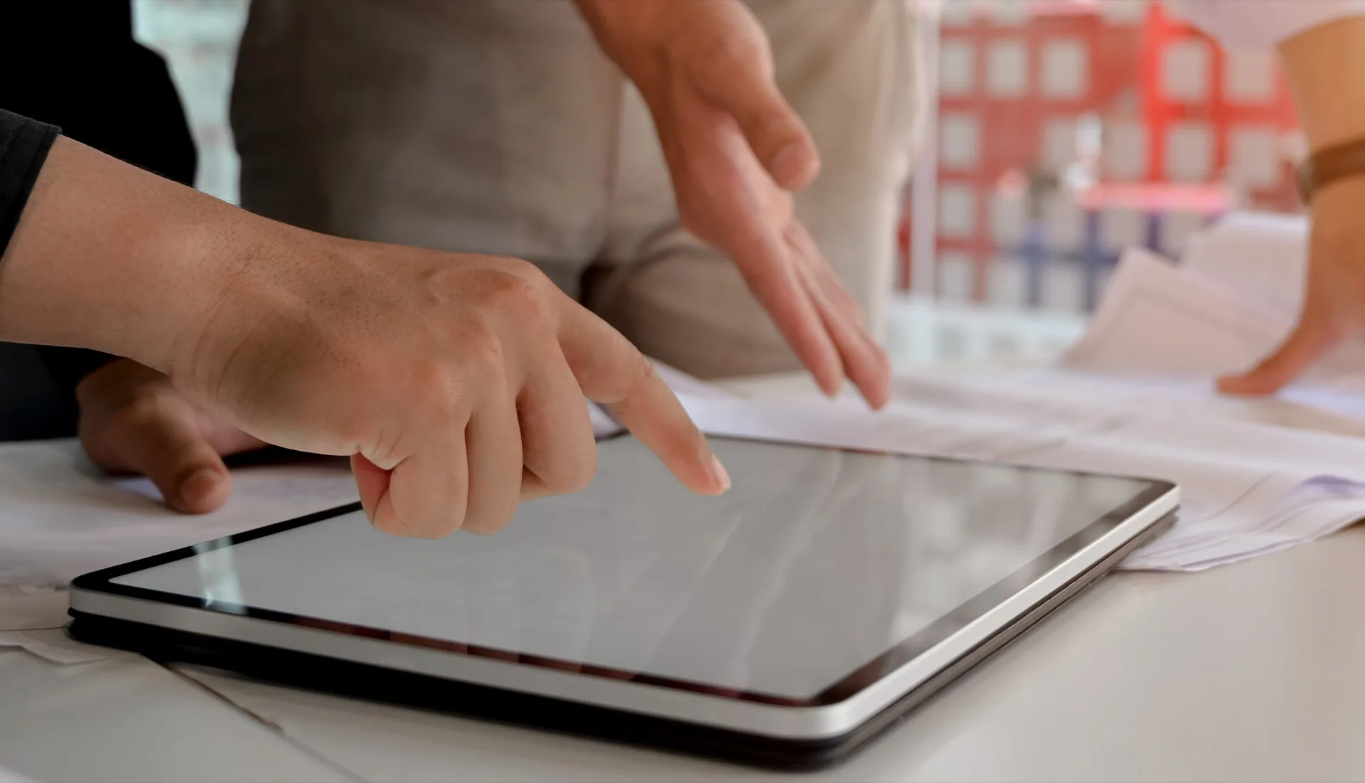Mani che indicano un tablet durante una consulenza.