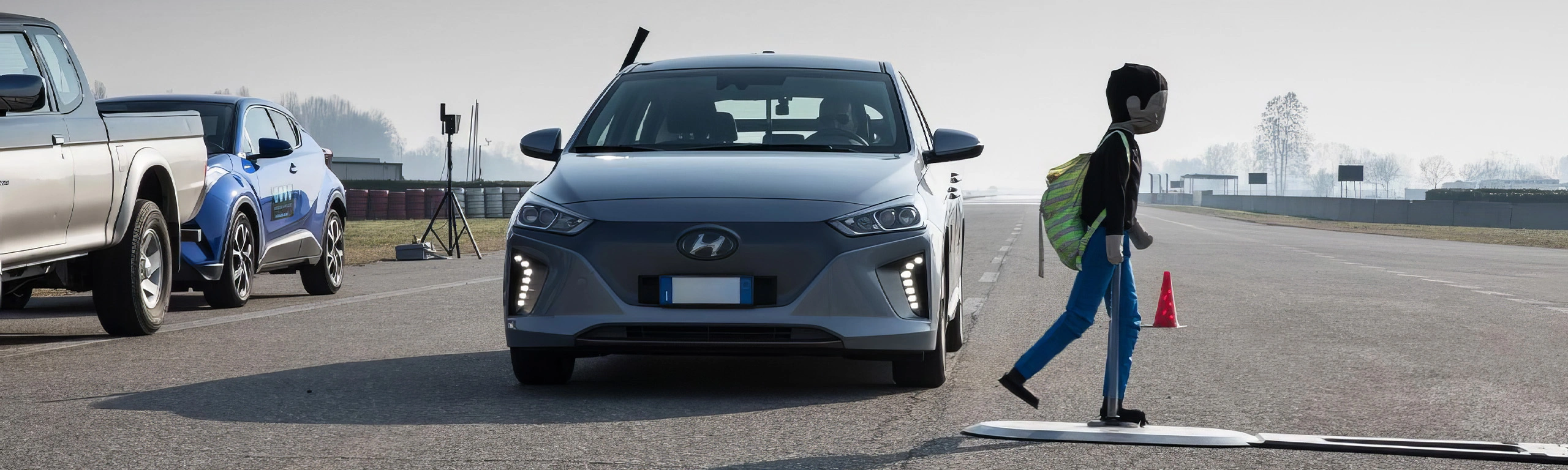 Auto in pista di test davanti a un manichino pedone.