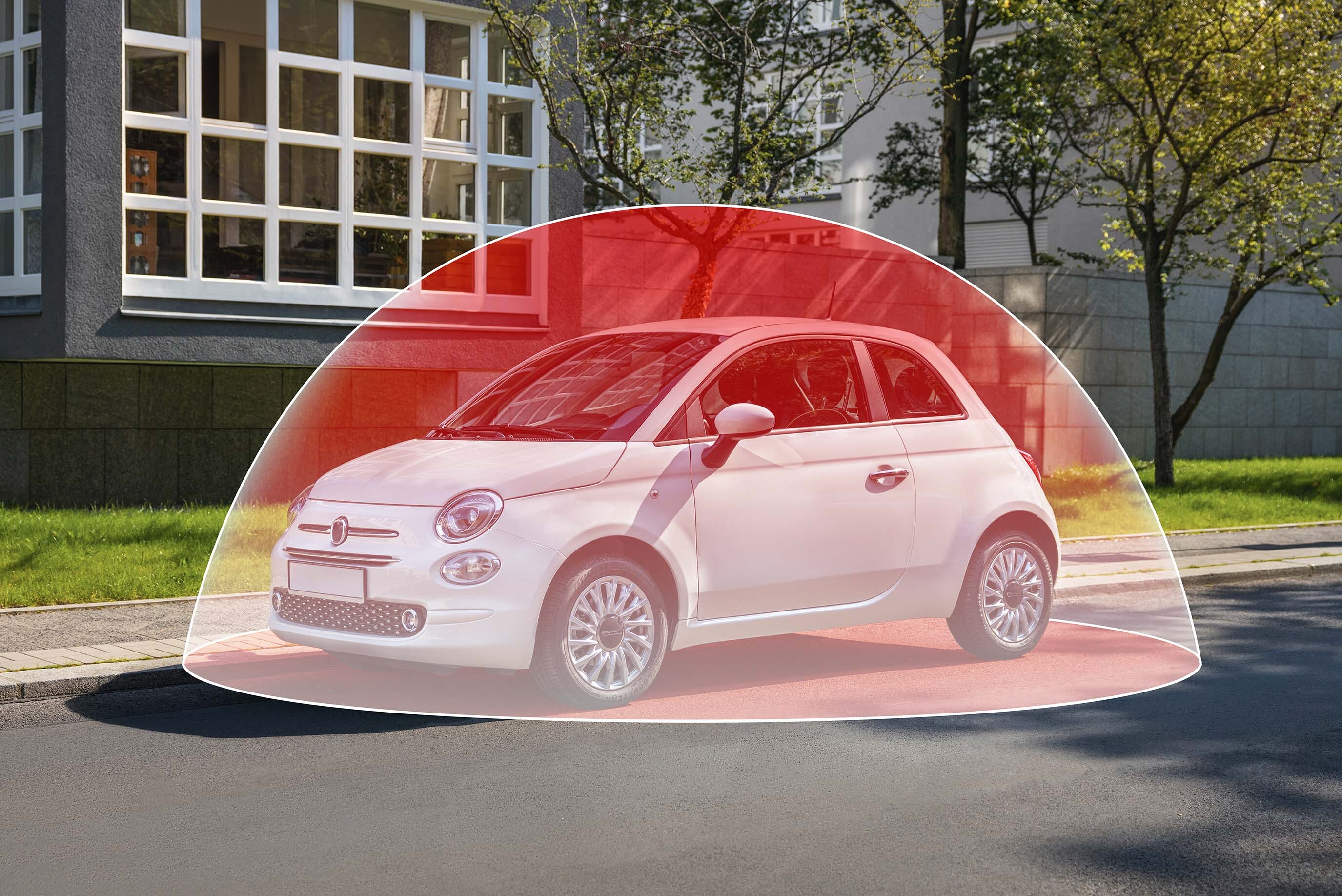 Auto bianca parcheggiata con area di copertura rossa evidenziata attorno al veicolo.