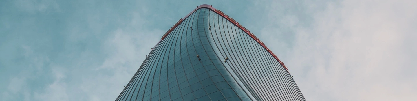 Grattacielo moderno in vetro visto dal basso verso il cielo.